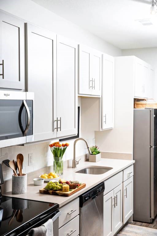 A modern kitchen with white cabinets and a black stove top.