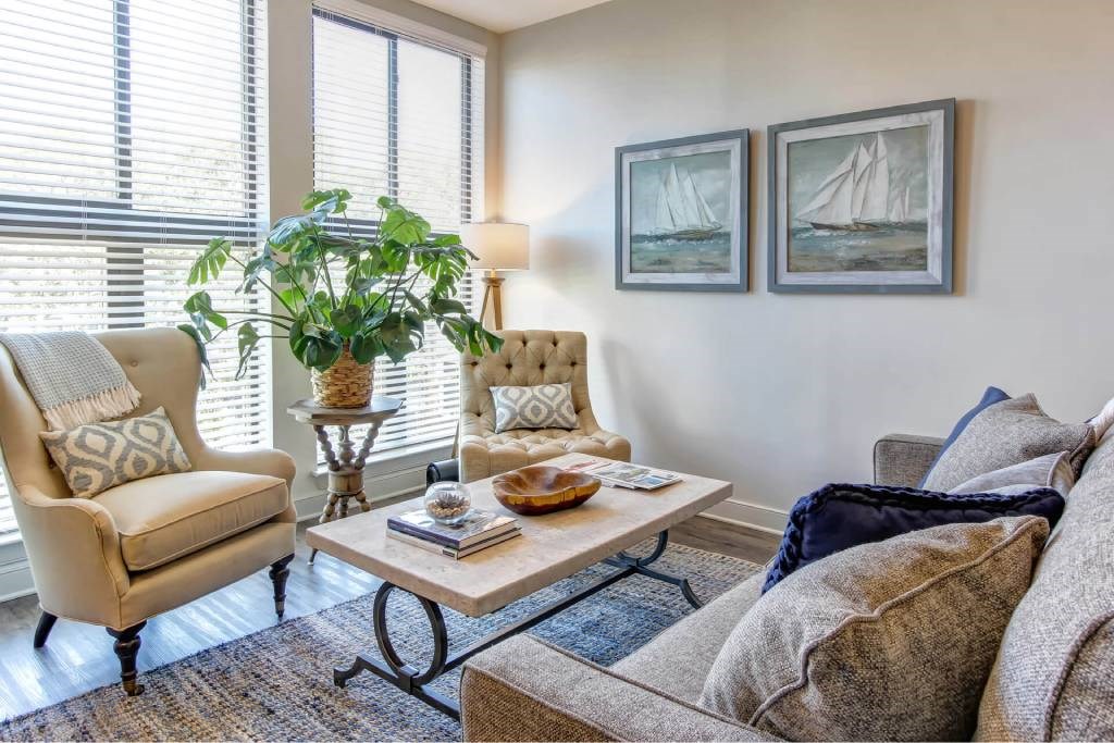 A living room with a couch, chair, and two pictures on the wall.