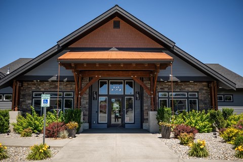 the front entrance of a brick building with a porch and a sidewalk at The Brix Apartments, Spokane Valley, WA, 99037