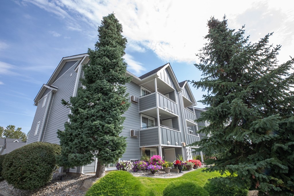 A grey apartment building with a green lawn at Morning Glory Circle Apartments, Washington, 99208