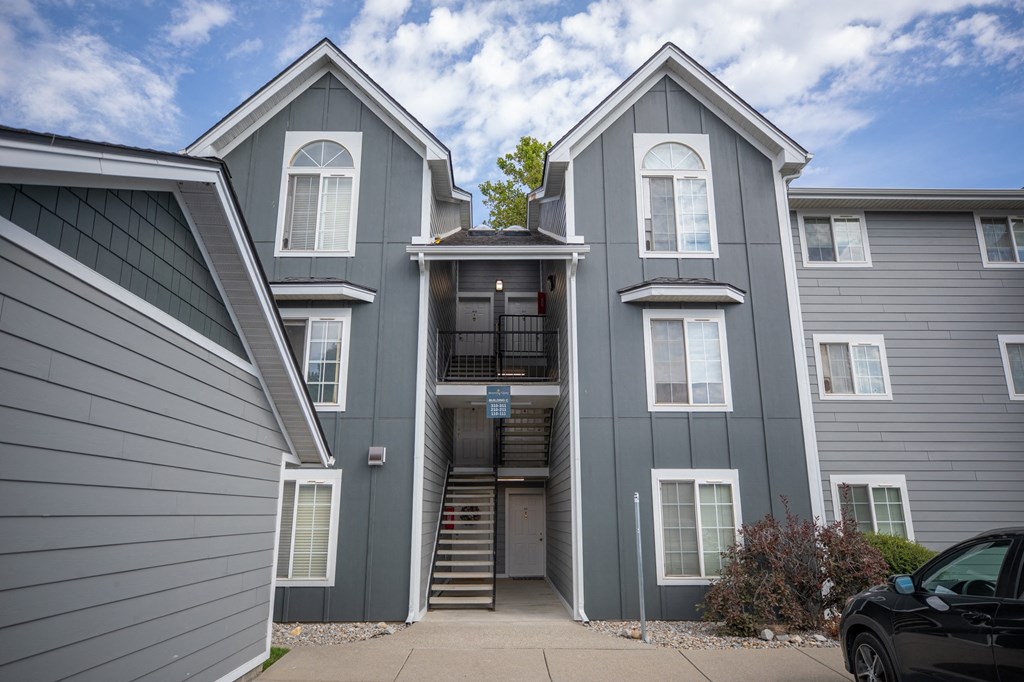 A grey two story house with a black car parked at Morning Glory Circle Apartments, WA