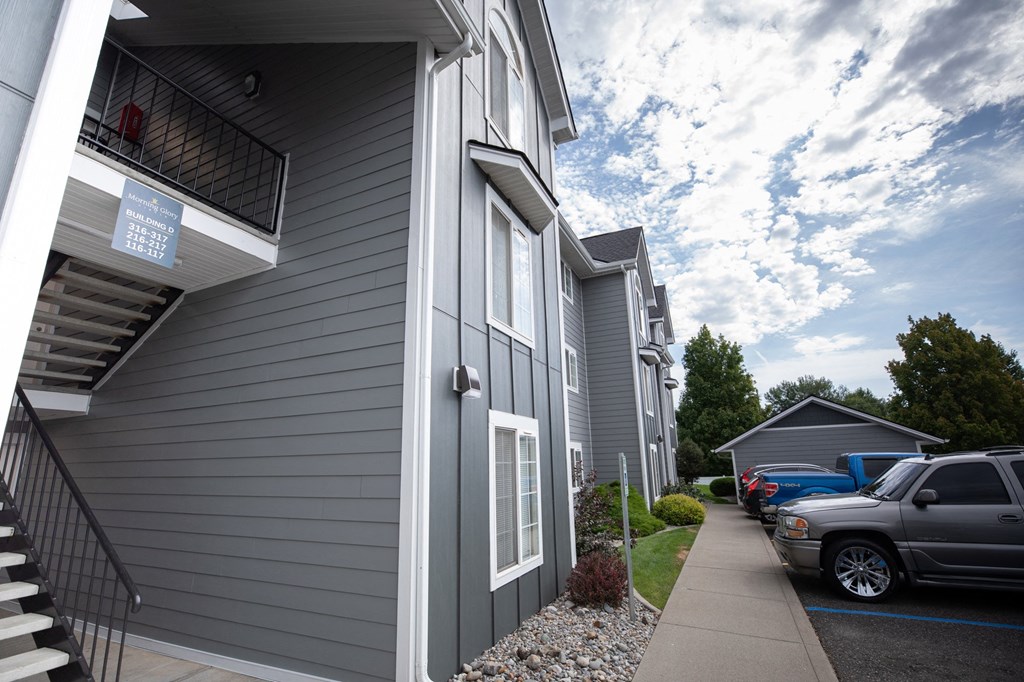 A grey building with a sign on the window at Morning Glory Circle Apartments, Spokane