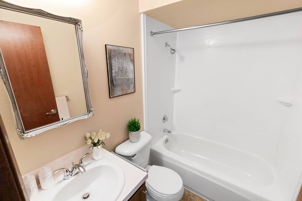 A white toilet sits next to a white sink in a bathroom.