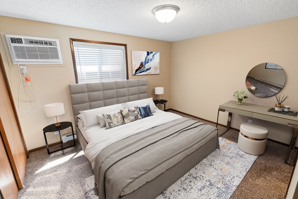 A bedroom with a bed, desk, and window.