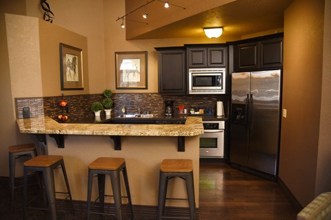 a kitchen with a granite counter top and a stainless steel refrigerator