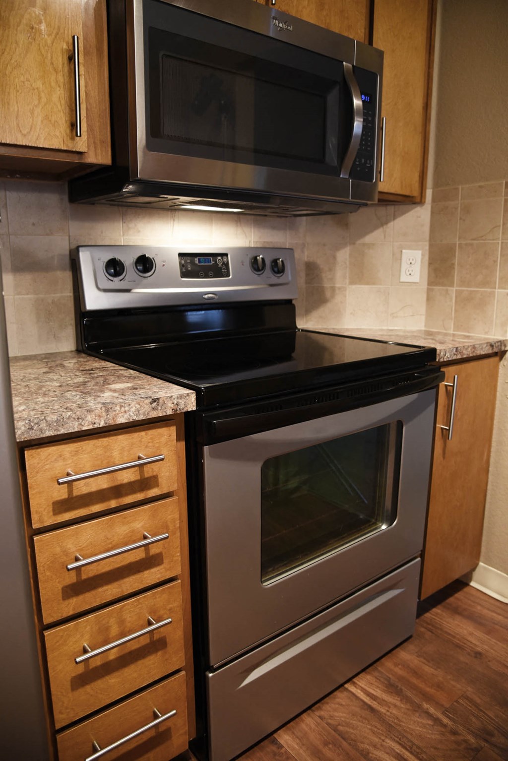 Kitchen cabinets with black appliances at Graymayre Crossing Apartments, Washington, 99208