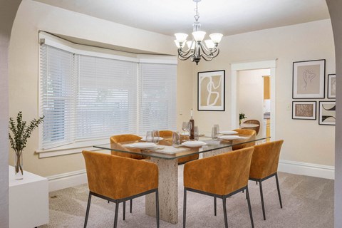 A dining room with a glass table and chairs.