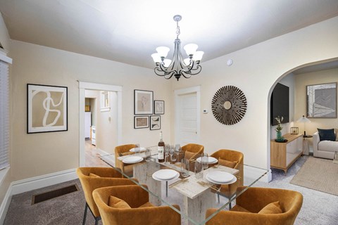 A dining room with a glass table and chairs.