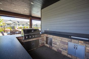 an outdoor kitchen with a barbecue and a patio