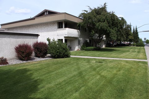 A house with a green lawn in front.