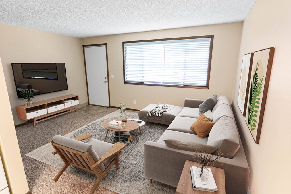 A living room with a grey couch, a wooden chair, a coffee table, and a flat screen TV.