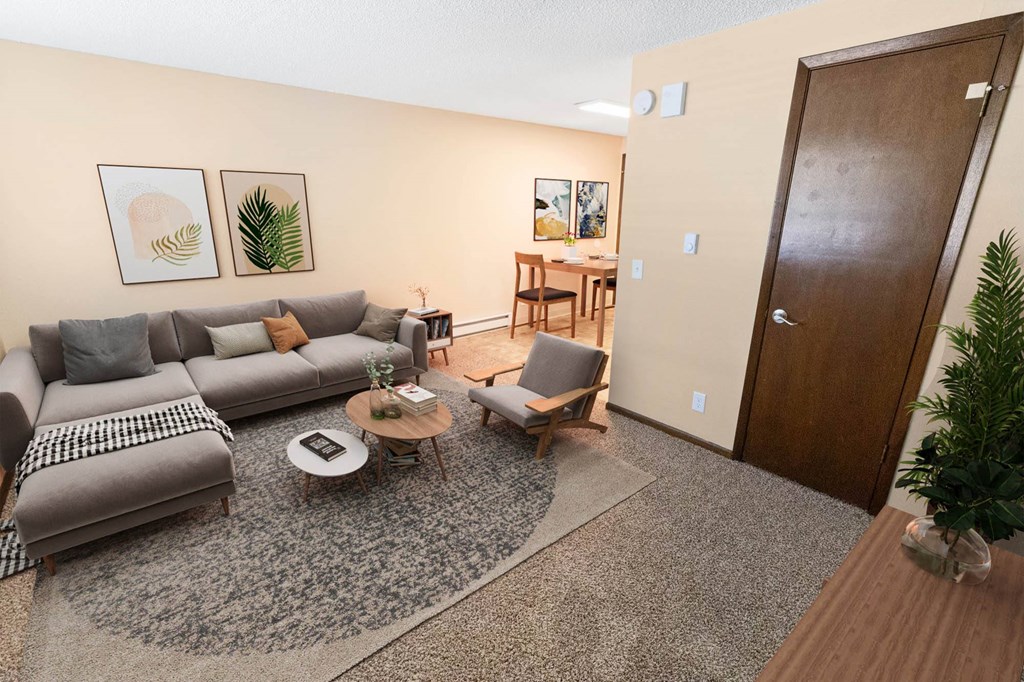 A living room with a grey sofa, a coffee table, and a wooden door.