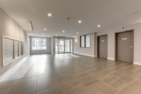 A spacious hallway with tiled floors and white walls.