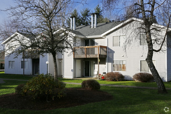 A white house with a grey roof and a balcony.
