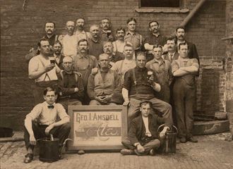 a group of men standing next to each other in front of a brick building