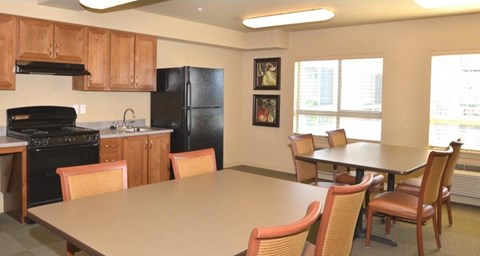 A kitchen with a table and chairs in front of a refrigerator.