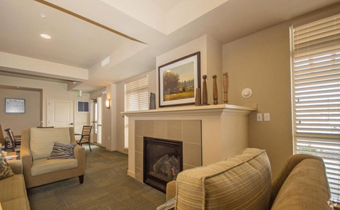A living room with a fireplace and a painting on the wall.
