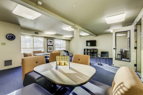 A conference room with a table, chairs, and a television.
