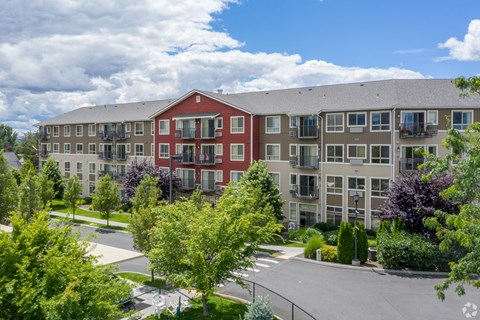 A large apartment complex with a red building in the front.