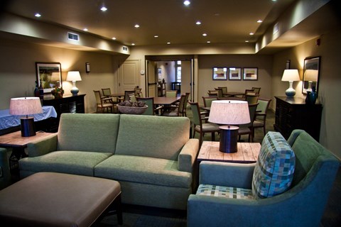 A living room with a green couch and a blue chair.