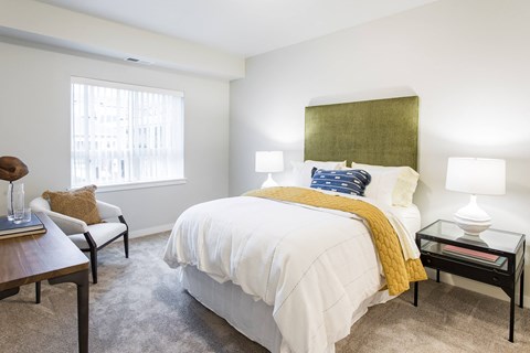 A bedroom with a white bed and a yellow throw.
