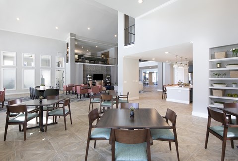A modern dining room with a large table and chairs.
