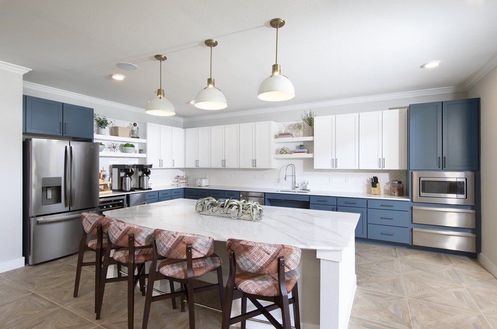 A kitchen with a table and chairs in the middle.