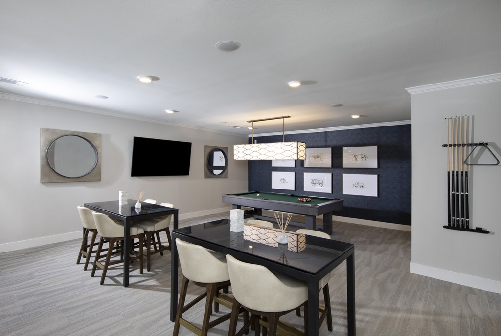 A modern dining room with a pool table and a bar area.