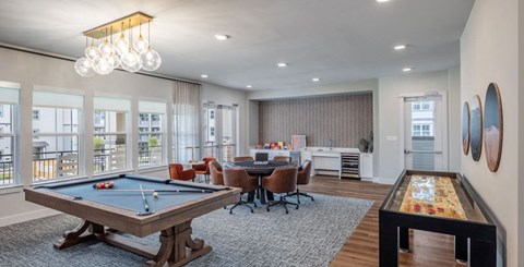 A room with a pool table and a foosball table.