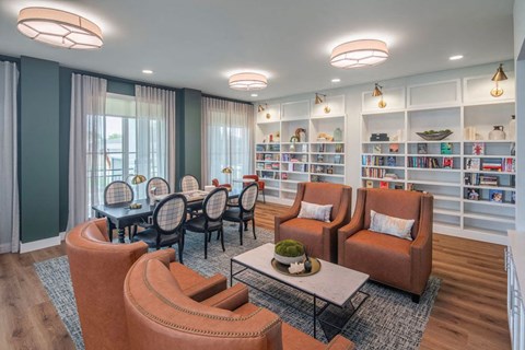 A living room with a dining table and chairs, a bookshelf, and a rug.