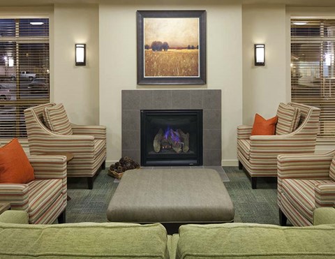 A living room with a fireplace and striped chairs.