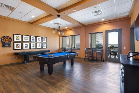 A room with a pool table and a bar.