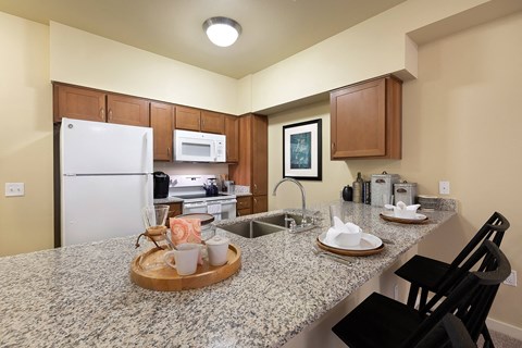 A kitchen with granite countertops and a white refrigerator.