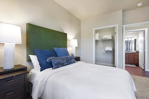 A bedroom with a bed, nightstand, and a green headboard.