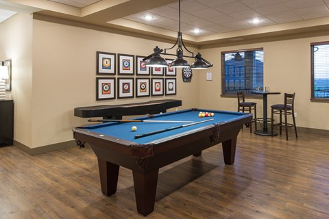 A pool table in a room with a light hanging from the ceiling.