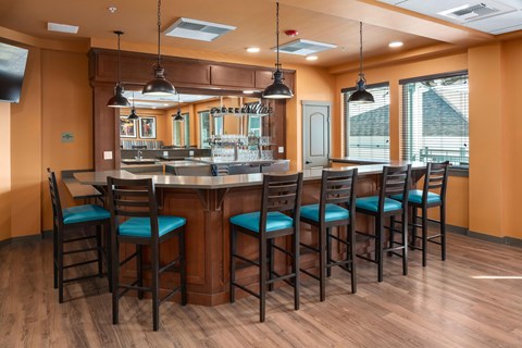 A kitchen with a bar area featuring a counter and chairs.
