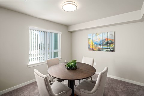 A dining room with a round table and chairs.