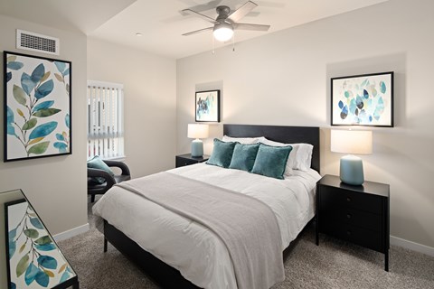 A bedroom with a large bed and two lamps.