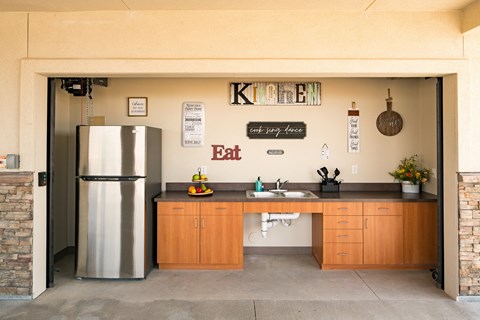A kitchen with a refrigerator and a sink.