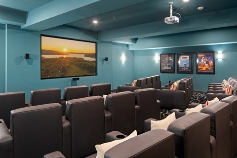 A cinema room with a large screen and comfortable seating.