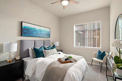 A bedroom with a large bed and a painting on the wall.