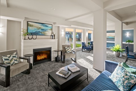 A modern living room with a fireplace and a painting on the wall.