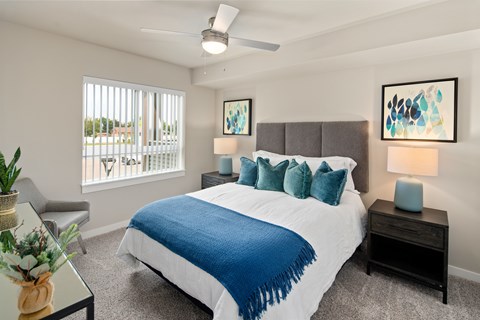 A bedroom with a large bed and a ceiling fan.