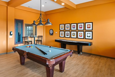 A pool table in a room with orange walls.