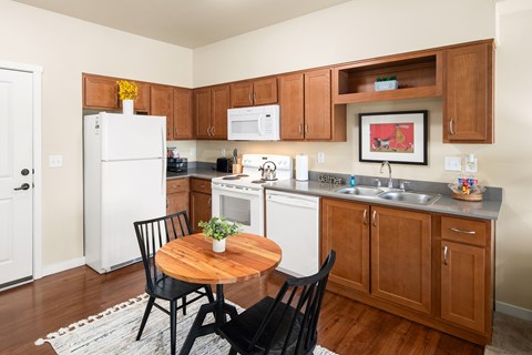 A kitchen with a table and chairs in the middle of it.