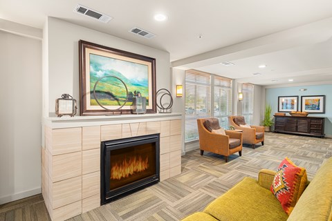 A living room with a fireplace and a painting on the wall.