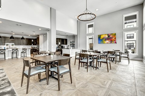 A modern dining room with a large table and chairs.