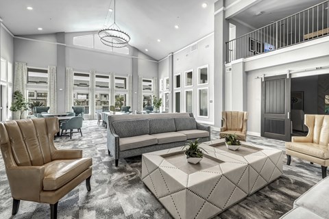 A modern living room with a grey sofa, a brown leather chair and a white coffee table.