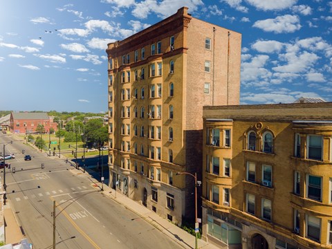 A tall brick building stands on a street corner.