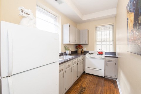 a kitchen with white appliances and a refrigerator